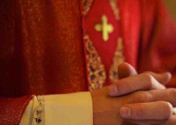 Sacerdote cattolico sullaltare in preghiera durante la messa